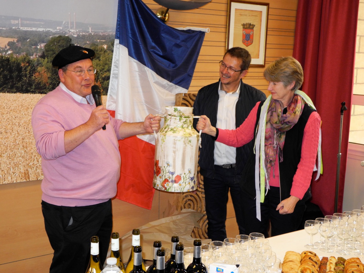 John Graham and Pat Duke receive the decorated milk churn from Philippe Ferrand